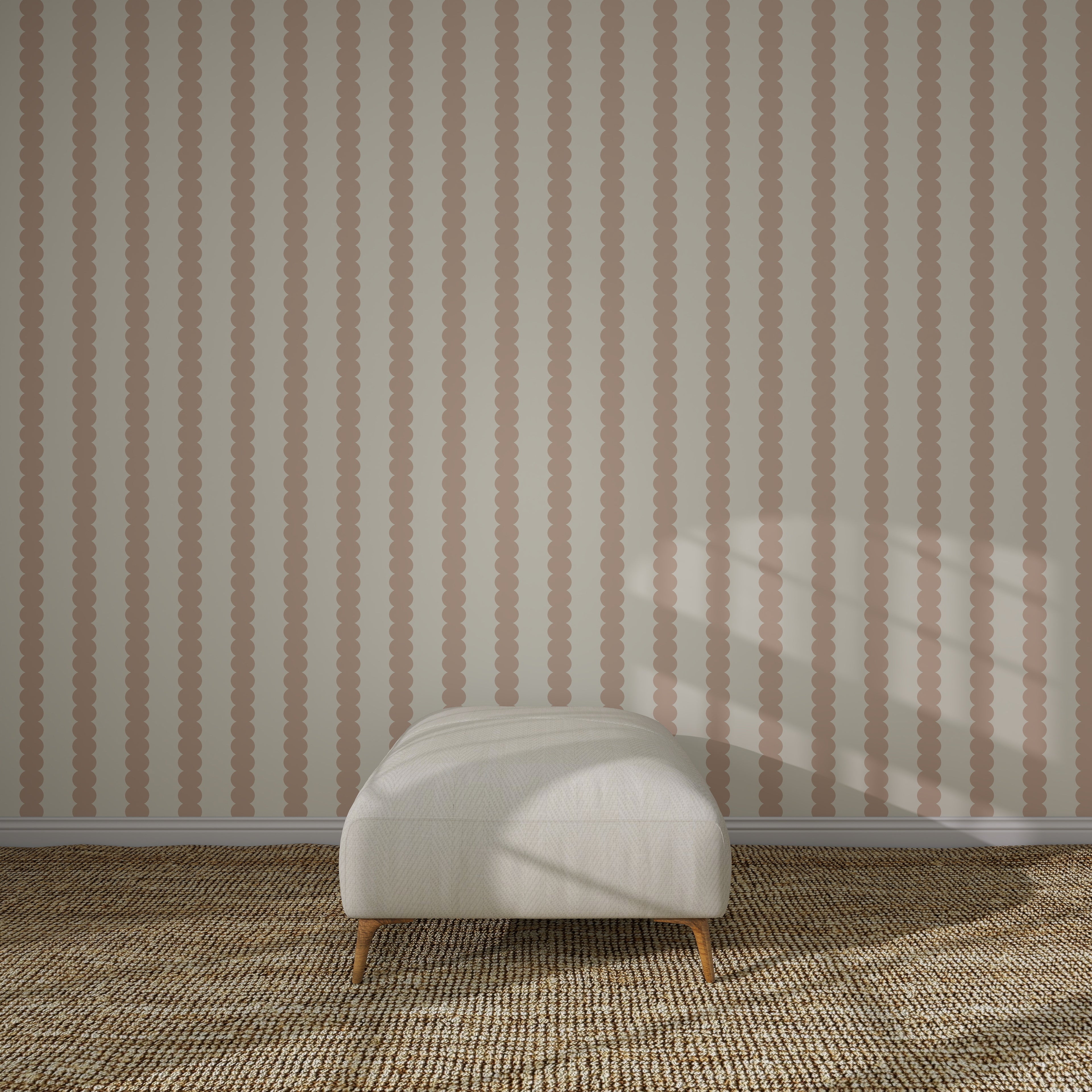 A white cushioned ottoman sits on a textured beige carpet in front of Scallop Stripe Wallpaper Pink. Sunlight casts soft shadows across the scene.