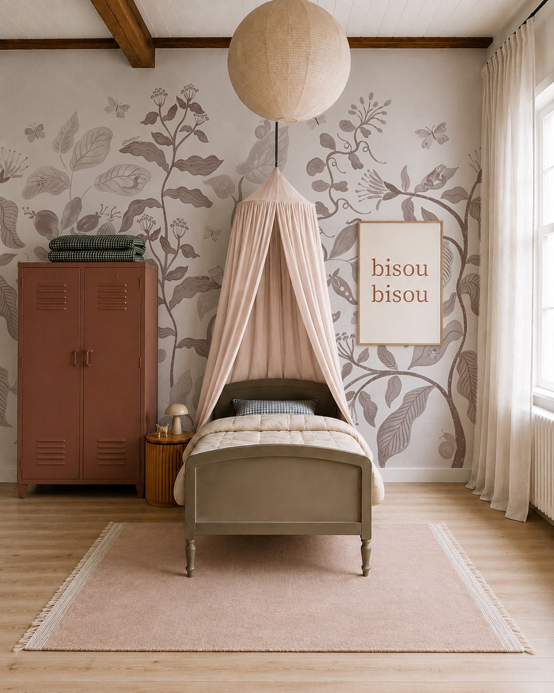 A cozy bedroom with a single bed under a pink canopy, Secret Garden Mural in Mocha, floral wallpaper, a brown locker, a lamp on a wooden nightstand, and a framed “bisou bisou” print. Soft light streams through large curtained windows.