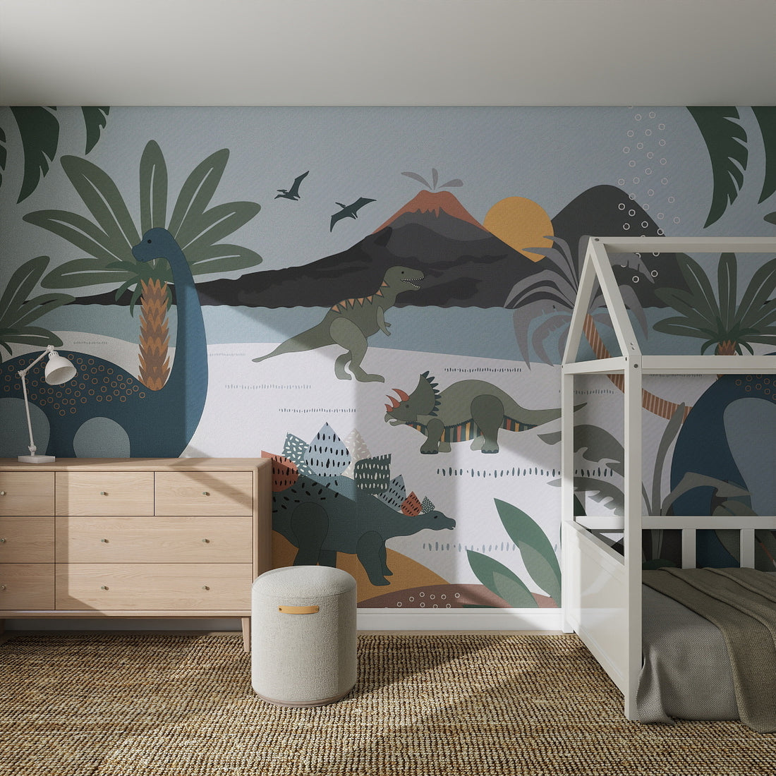 Children’s bedroom featuring the Dinosaur and Friends Wallpaper Mural with colorful dinosaurs, volcanoes, and palm trees. Includes a wooden dresser, white bunk bed, round ottoman, and woven rug for a playful nursery space.