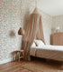 Bedroom with floral wallpaper, wooden floor, and canopy bed.