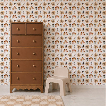 A tall brown dresser stands next to a small beige plastic chair, set against a wall decorated with the Sun and Rainbows Wallpaper. The light wood floor features a tan and white checkered rug partially in view.