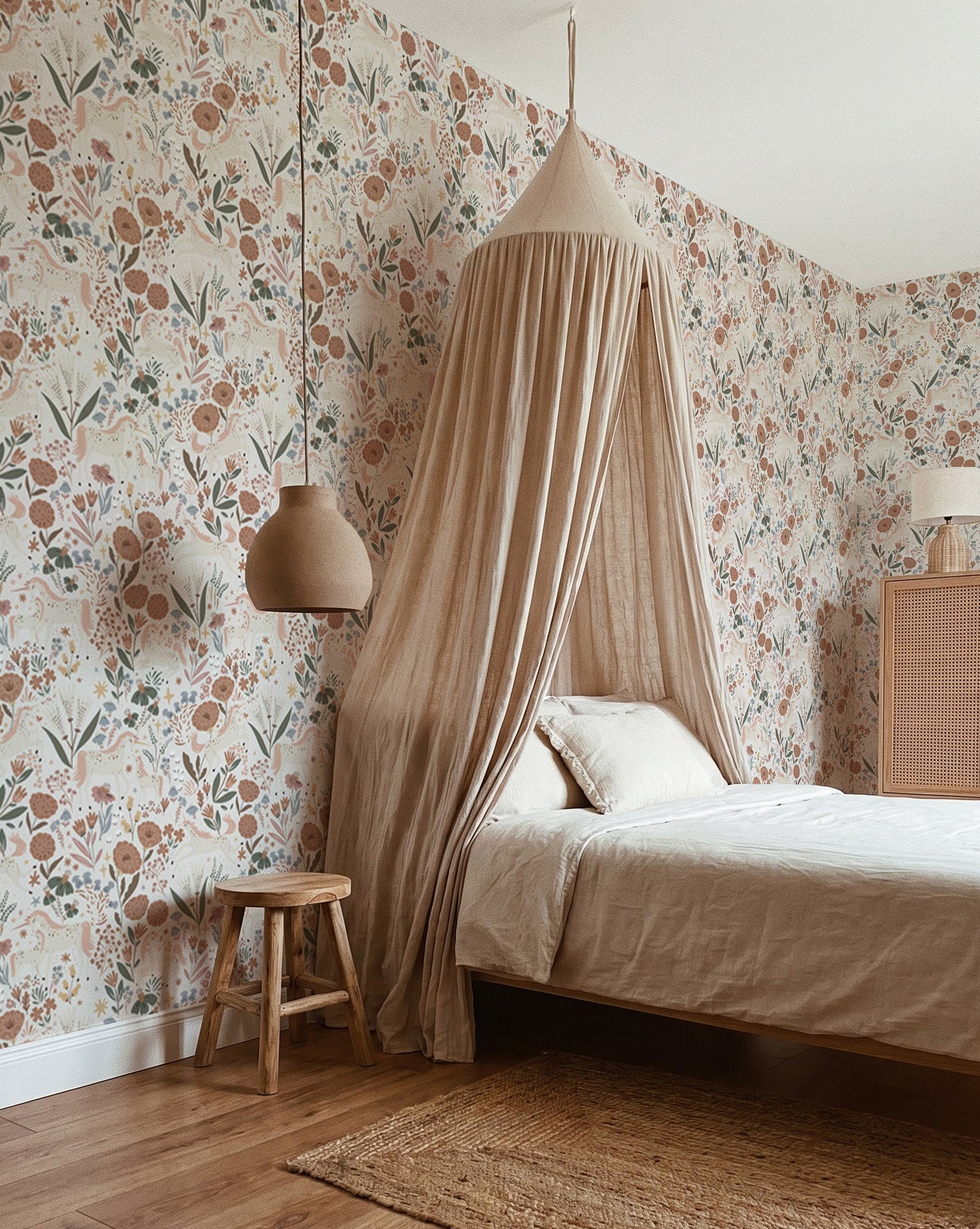 A cozy bedroom featuring Unicorn Meadow Wallpaper in Cream, a bed with a beige canopy and bedding, wooden stool, pendant light, woven rug, rattan cabinet, and wooden floor—perfect for girly room decor.