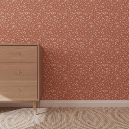 A light wood dresser with three drawers sits on a beige patterned rug in front of a wall featuring Butterfly Meadowland Wallpaper Repeat Pattern Terracotta, displaying cream florals and colorful butterflies with warm terracotta tones.