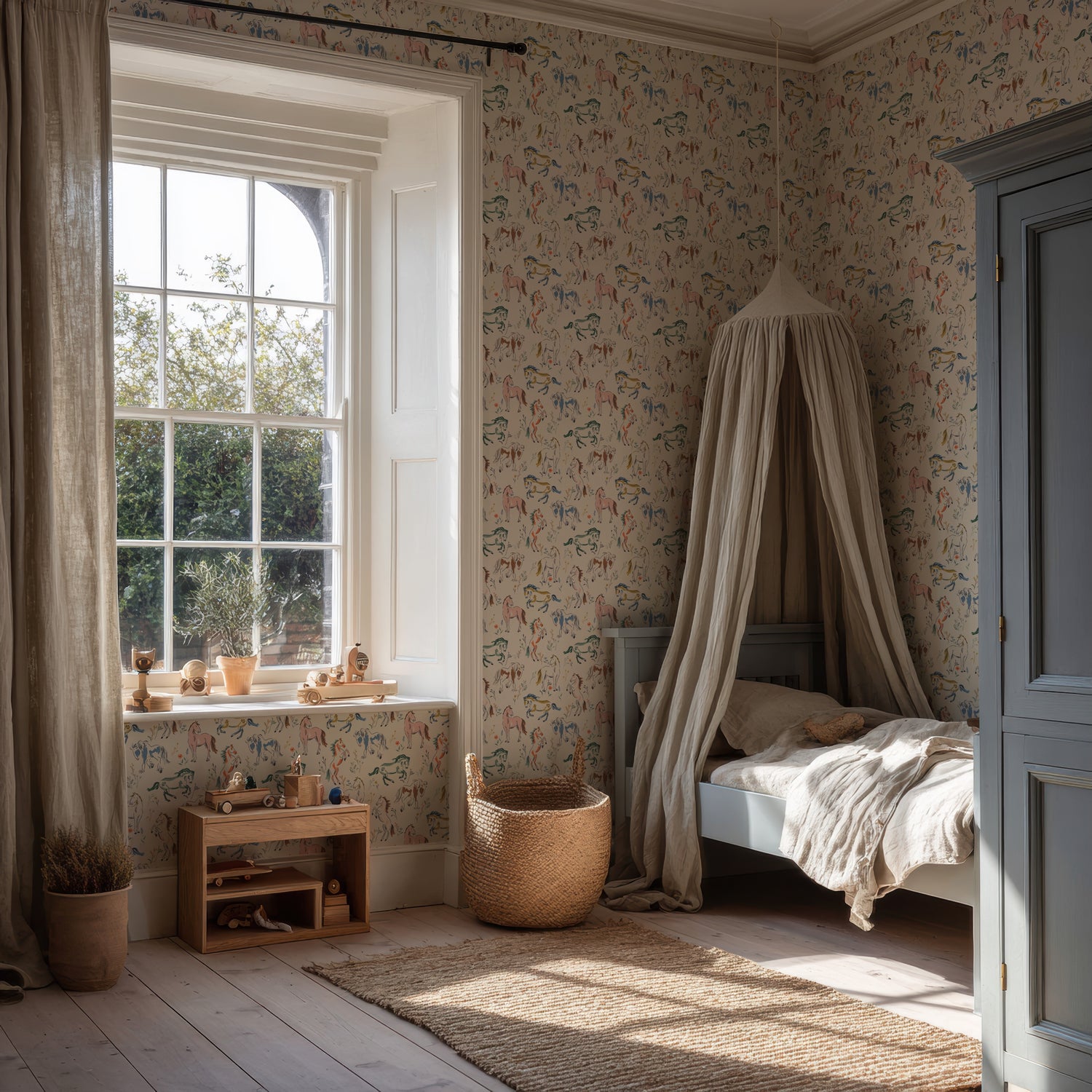 A cozy children’s bedroom with a bed under a canopy, Wild At Heart Wallpaper featuring whimsical, hand-drawn designs, wooden toys on a shelf, a large window with flowing curtains, and sunlight streaming in. A woven basket and natural decor create a warm, inviting atmosphere.