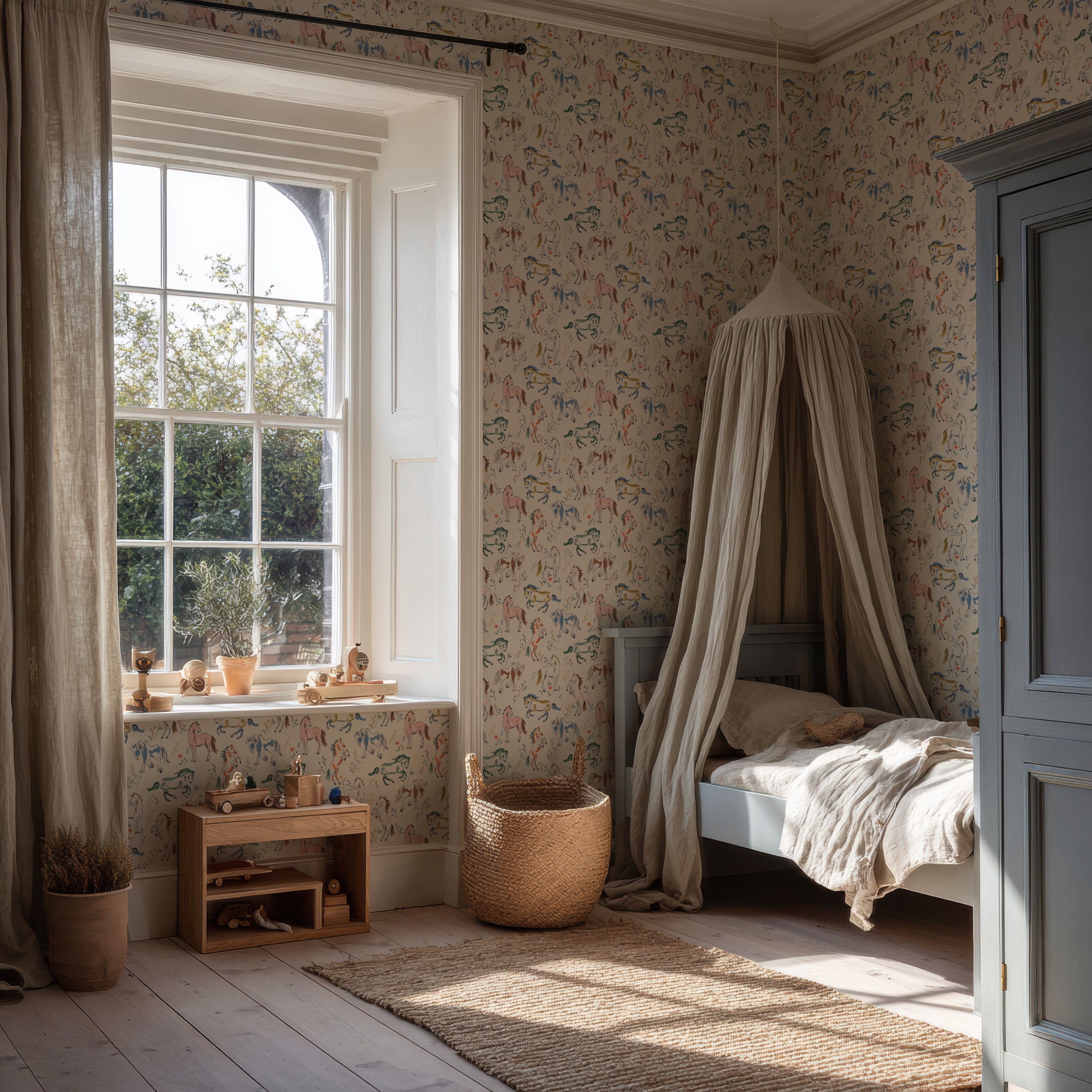 A cozy children’s bedroom with a bed under a canopy, Wild At Heart Wallpaper featuring whimsical, hand-drawn designs, wooden toys on a shelf, a large window with flowing curtains, and sunlight streaming in. A woven basket and natural decor create a warm, inviting atmosphere.