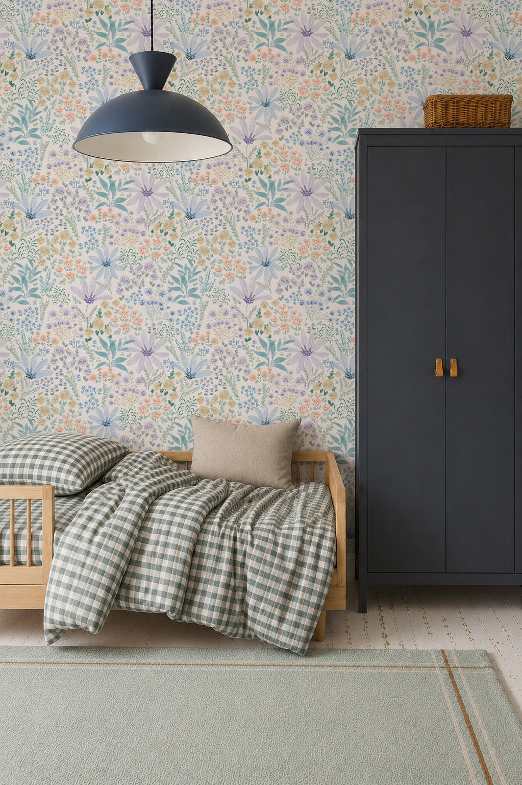 A cozy bedroom with a wooden bed, checkered bedding, a beige pillow, and a dark wardrobe is beautifully accented by the Wildflower Waltz Wallpaper, adding a touch of nature decor. A woven basket sits atop the wardrobe while a modern pendant lamp hangs overhead.