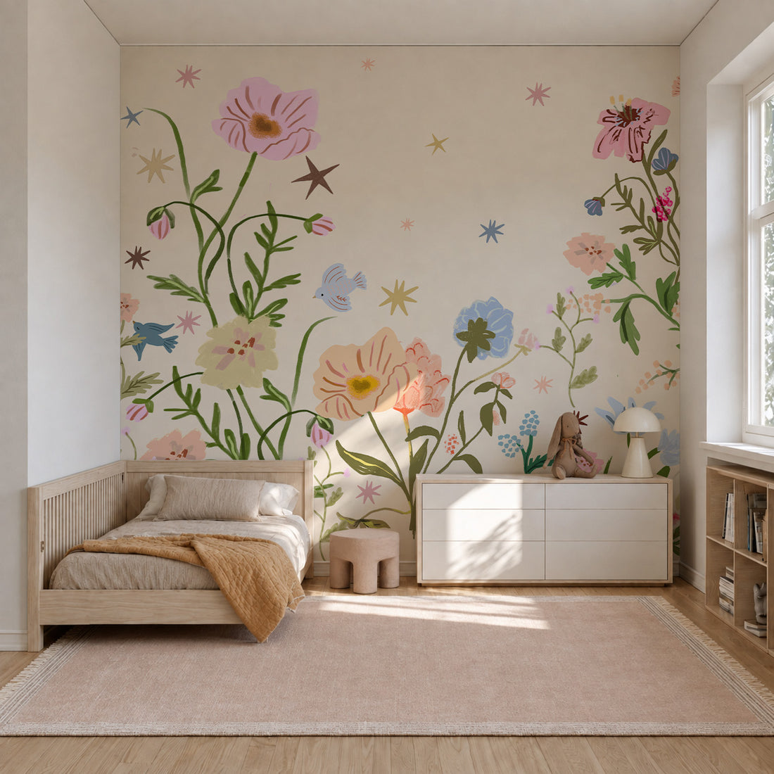 A child’s bedroom featuring The Wishing Garden Sample, Cream wall mural of oversized, whimsical flowers, small birds, and stars in soft pastels, with a wooden daybed and white storage console.