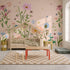 A child’s bedroom featuring The Wishing Garden Pink floral wallpaper mural, a wooden house-shaped bed, a small table with a stool, and a checkered rug.