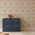 A blue four-drawer cabinet stands on a wooden floor, topped with wooden boxes and a decorative giraffe. The wall behind is adorned with the "You&